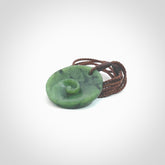 This pendant is a small sized and cupped koru necklace carved from a dark green piece of New Zealand Marsden Jade. Kyohei Noguchi carved this piece for us so the workmanship is outstanding. Handmade in New Zealand, a beautiful piece of jade jewellery. Provided with an adjustable brown cord and packaged in a woven kete pouch.